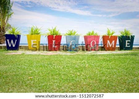Welcome written on a colorful blocks at tropical beach, sea , sky green, resort image
