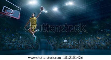 Female basketball player makes slam dunk. Basketball player on big professional arena during the game