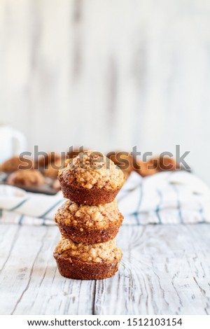 Beautiful fresh baked homemade pumpkin muffins stack on top of each other against a white background. Selective focus on bread in front with blurred background.