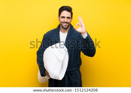 Handsome man in pajamas showing ok sign with fingers