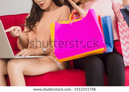 Two Asian women are enjoying shopping online from websites with laptop computer from home,concept cashless society with e banking, modern wireless communication technology and Fast with technology 4.0
