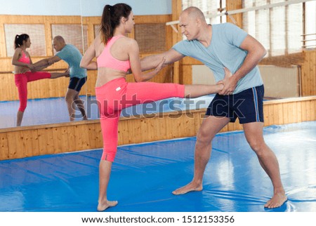 Woman is training with man on the self-defense course in gym