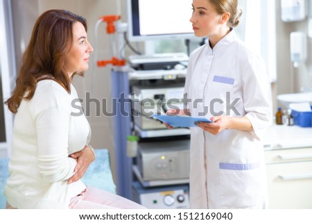 Attentive young professional is examining patient in modern endoscopy office