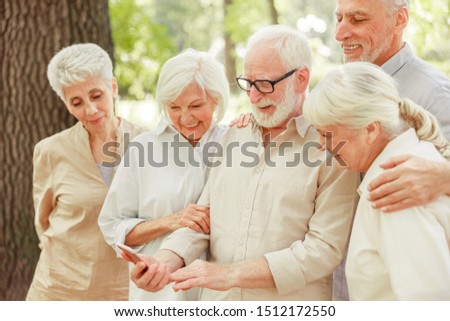 Cheerful senior people watching funny video on smartphone stock photo