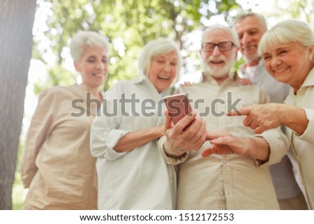 Joyful old people watching funny video on cellphone and laughing stock photo
