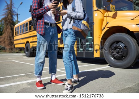Couple with backpacks using smartphones stock photo