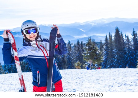 Young woman with ski in winter time on top of mountains