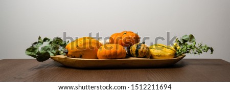 Orange flat pumpkins on a wooden bowl