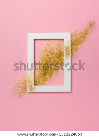 Golden shimmer glitter celebration flat lay with champagne glass on pink background, copy space, top view, vertical