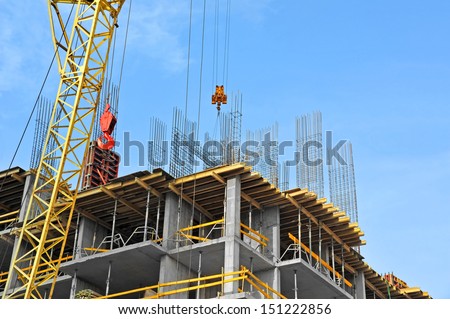 Crane and building construction site against blue sky Royalty-Free Stock Photo #151222856