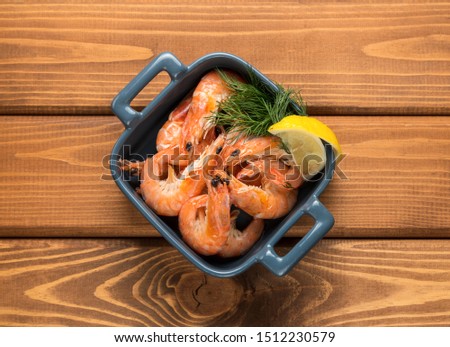 Prawns with lemon and dill on wood