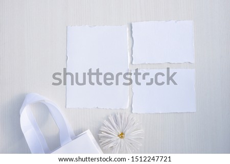 Stylish branding mockup to display your artworks.  Mock up on wooden table background. Flat lay top view. Blank greeting card. Feminine wedding stationery, desktop scene with flower.