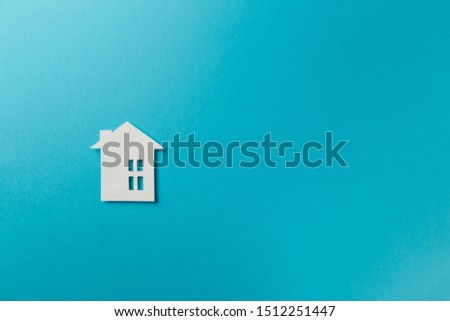 Minimalistic paper house on a blue background. Top view. Flat lay. Copy space. Colorful background. New minimal creative concept