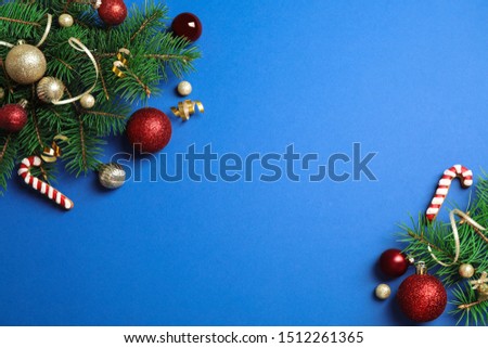 Fir tree branches with Christmas decoration on blue background, flat lay. Space for text