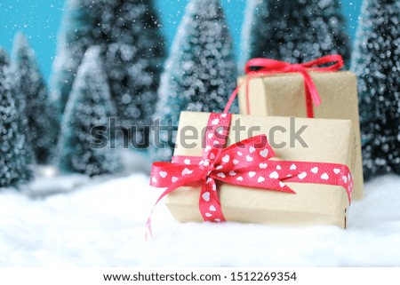 Christmas background with gift boxes and blurred christmas trees on table.