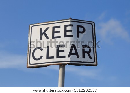 Keep clear road sign in blue sky background, horizontal