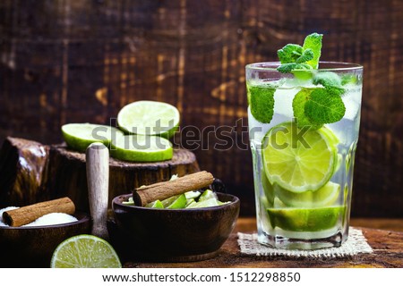 Mojito cocktail at the bar. Mojito cocktail over rustic wood. Cold Mojito, rum, lime and mint tourist drink.
