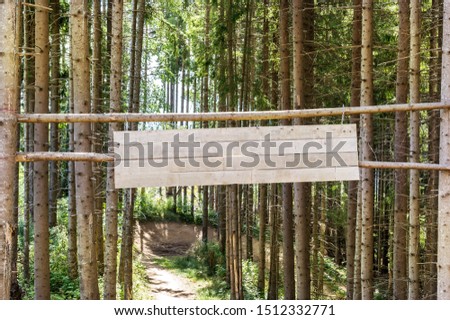 Blank wooden signboard in the forest.