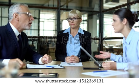 Business woman listening to emotional colleagues arguing in office, conflict