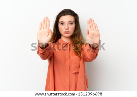 Young brunette girl over isolated white background making stop gesture and disappointed