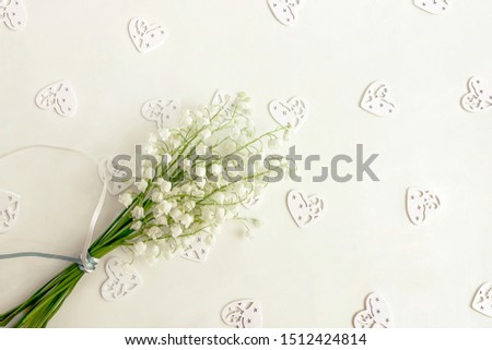 Lilies of the valley on a light background. Heart silhouette on the background. Bouquet of spring flowers. Selective focus