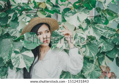 Portrait photo of young beautiful Asian woman with green leaves.