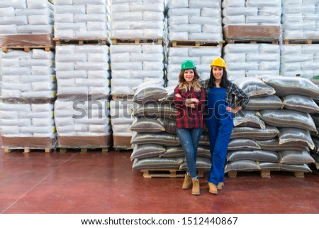 worker standing crossed arms in front of seeds in sack in warehouse