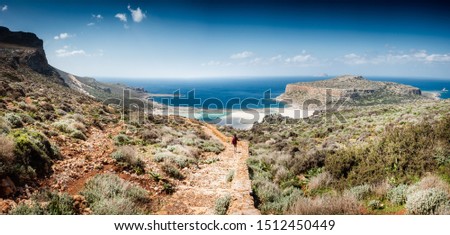 Boy walking on footpath mountains over looking blue sea