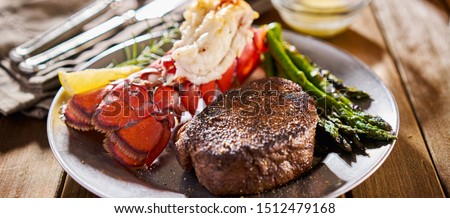 tasty surf & turf steak and lobster meal with asparagus on dinner plate Royalty-Free Stock Photo #1512479168