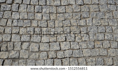 Texture road surface made of natural stone gray cobblestones