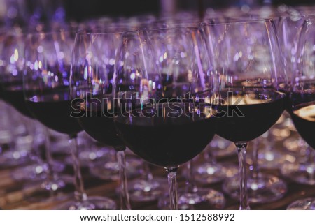 A selective focus picture of glasses of red wine with vintage filter.