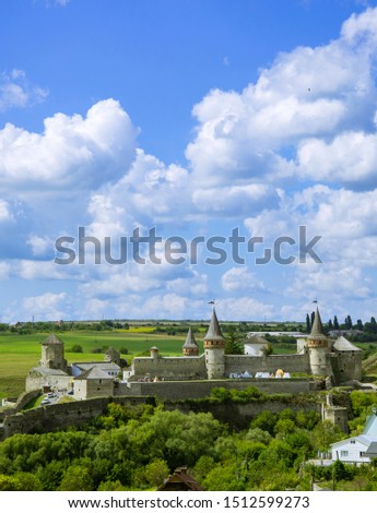 vertical picture of Eastern European castle on green hill and blue sky white clouds background in Ukraine 