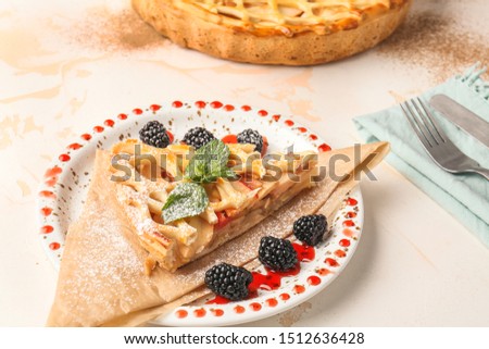 Plate with tasty apple pie on light table