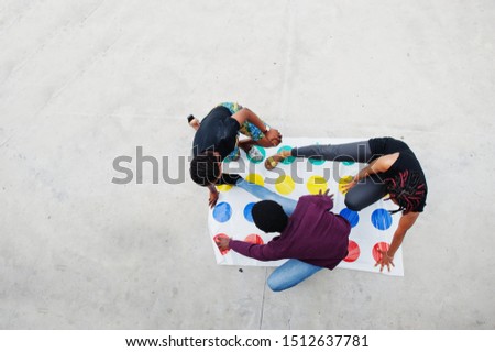 Group of three african american friends play twister game outdoor. Royalty-Free Stock Photo #1512637781
