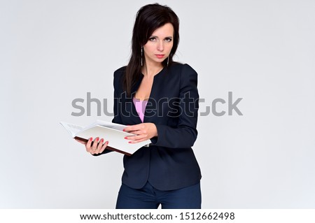 Portrait of a brunette manager woman in a business suit on a white background with a folder in her hands. Great makeup and beautiful hair. Standing right in front of the camera in various poses.