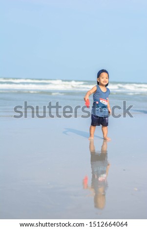 Thai boy smiles and playing on the beach on summer time at Samui island with copy space