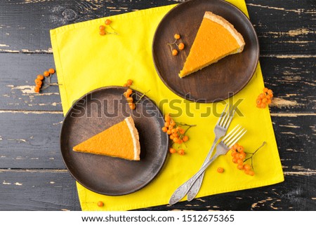 Plates with pieces of tasty pumpkin pie on table
