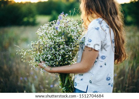 beautiful girl with a bouquet of wildflowers on Ivan Kupala. woman in field with flowers. summer bouquet of field daisies.