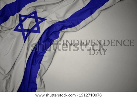waving colorful national flag of israel on a gray background with text independence day. concept