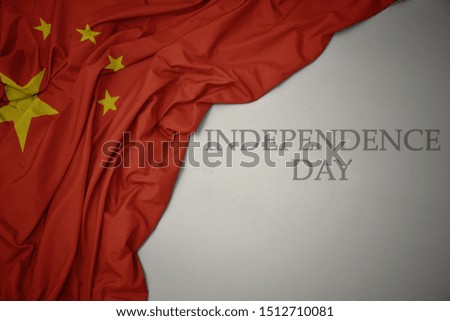 waving colorful national flag of china on a gray background with text independence day. concept