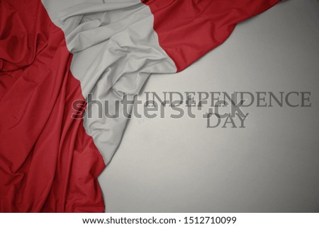 waving colorful national flag of peru on a gray background with text independence day. concept