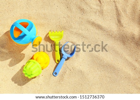 Flat lay composition with plastic beach toys on sand. Space for text Royalty-Free Stock Photo #1512736370