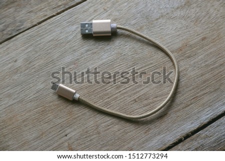 Micro usb cable on a wooden background.