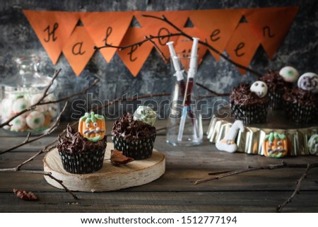Chocolate Cupcakes with Chocolate Cream Decorated with Creepy Marshmallow Sweets for Halloween Party. Halloween food.