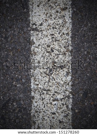 Black road texture with a white stripe