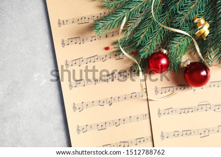 Flat lay composition with Christmas decorations and music sheets on table