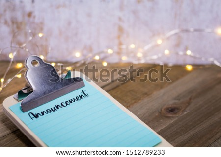 Announcement concept with words on paper and clipboard 