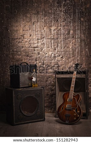 Electric guitar and old amplifier on a grunge wall background 