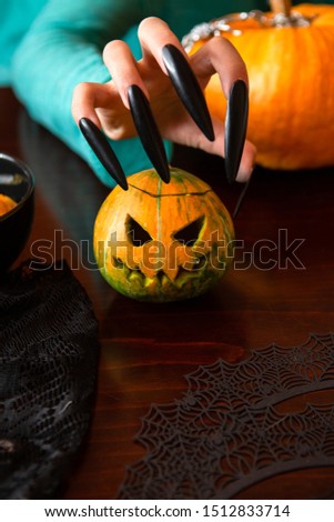 Image of man's hands with pumpkin jack sitting at wooden table