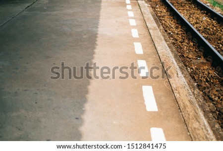 Footpath floor at the edge of the railway road and with white lines